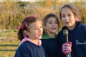 Three young girls share a microphone at Making Strides of Long Island 2012