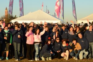 A large group o people poses with their hands in the air at Making Strides of Long Island 2012