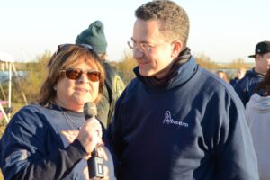 Dr. Ron Israeli stands beside and listens to a woman with sunglasses who is holding a microphone at Making Strides of Long Island 2012