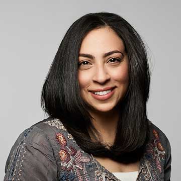 Color photo of woman, Sarah, with shoulder length hair, softly smiling for the camera.