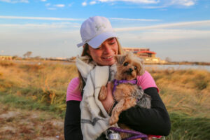Woman in cap holding dog atMaking Strides of Long Island 2019
